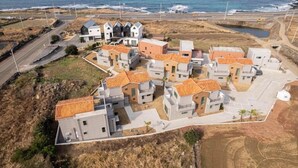 Een kustwoongebied met moderne huizen, herkenbaar aan oranje pannendaken en een gevarieerde bouwstijl.