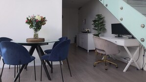 A modern living space with a dining area, a computer desk, and a staircase. - Rare Loft Style Penthouse Bourke St Mall + Parking (Melbourne)