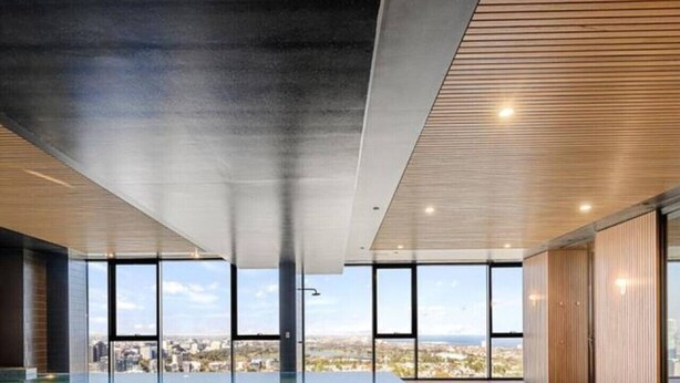 Una piscina interna moderna con pareti di vetro trasparenti, pavimento piastrellato e vista sulla città.