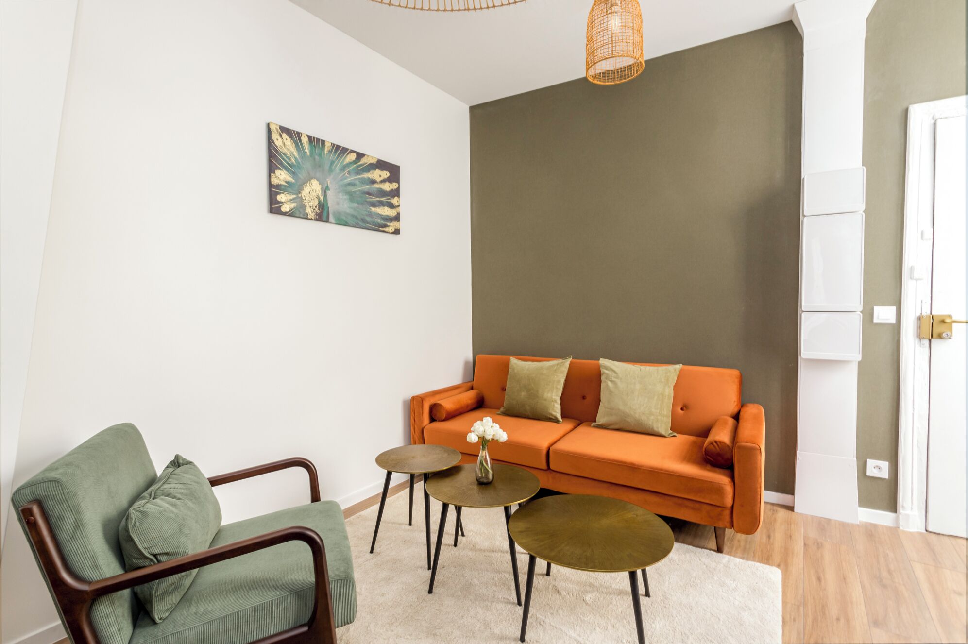 Una sala de estar moderna con un sofá, una silla y una mesita con un jarrón.