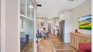 A modern kitchen with a refrigerator, dining table, and chairs. - Navvy Town Neighborhood at Heritage Harbor (Ottawa)