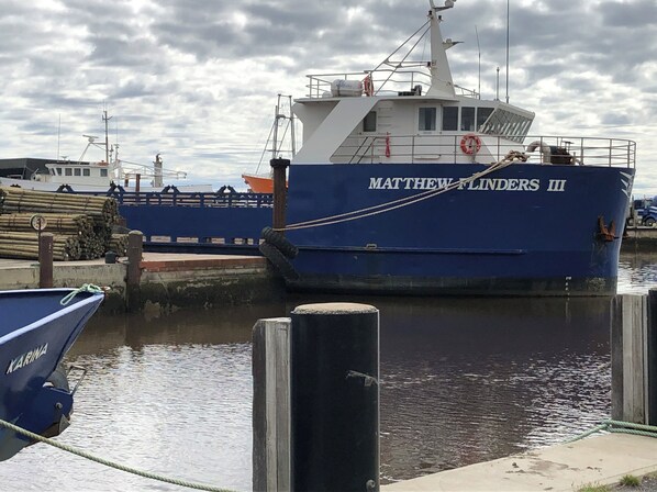 Un barco llamado 'Matthew Flinders III' atracado, con casco azul y superestructura blanca.