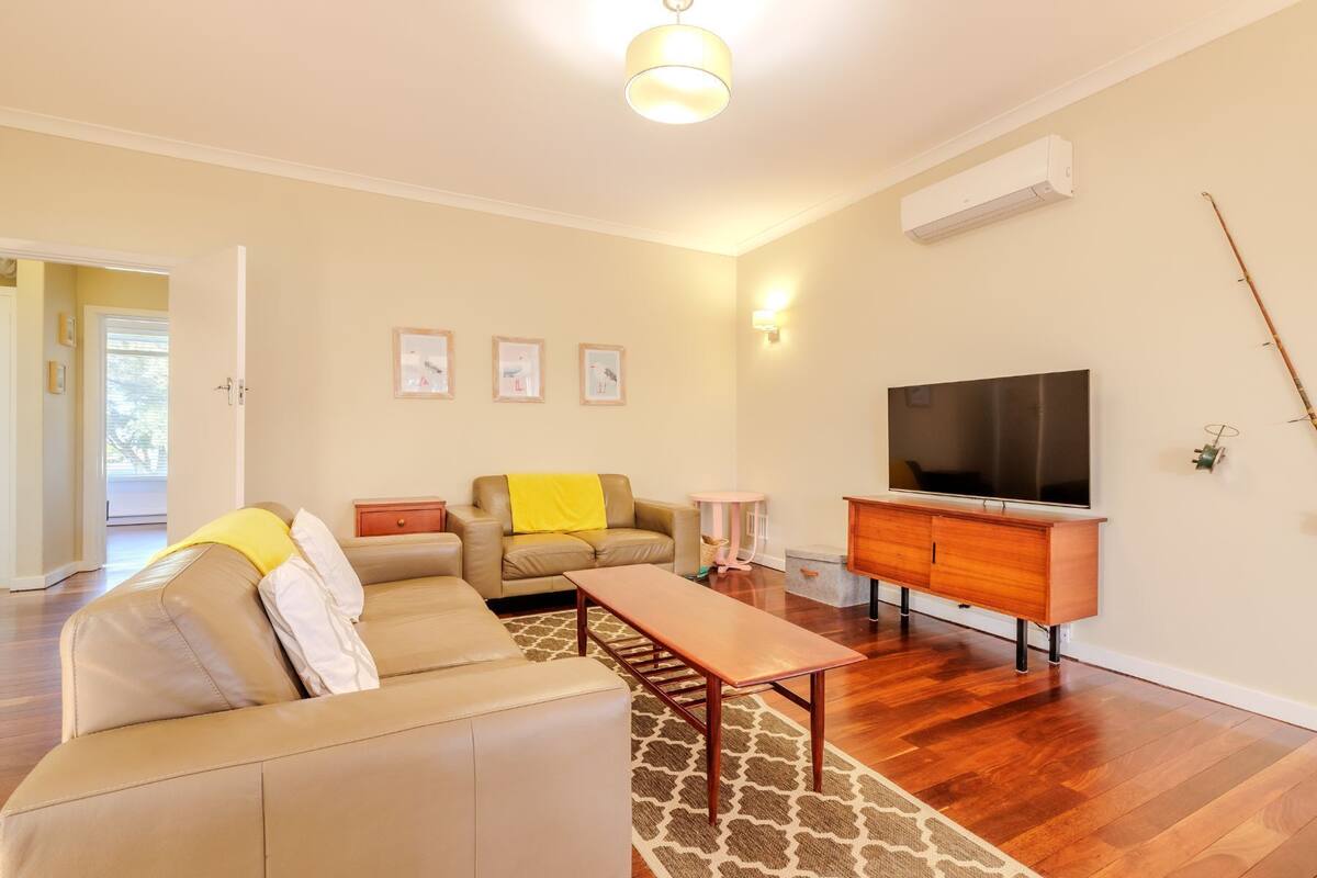 A living room with a sofa, a coffee table, a TV, and a wooden cabinet.