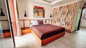 Un dormitorio moderno con una cama grande, un cabecero de madera, un cuadro abstracto de colores y una puerta corredera de madera.