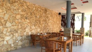 Un restaurante con paredes de piedra y muebles de madera.