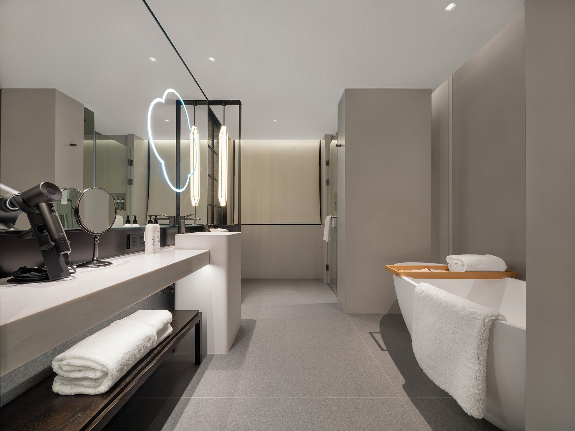 A modern bathroom with a vanity, mirror, and towel rack.
