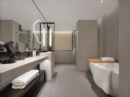 Un baño moderno con tocador, espejo y perchero.