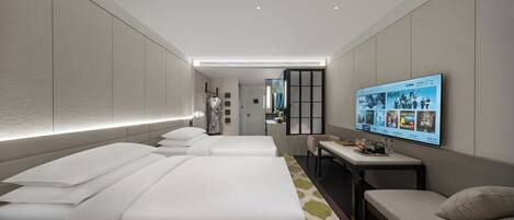 Una habitación de hotel moderna con dos camas, un escritorio, un televisor y una zona de estar.