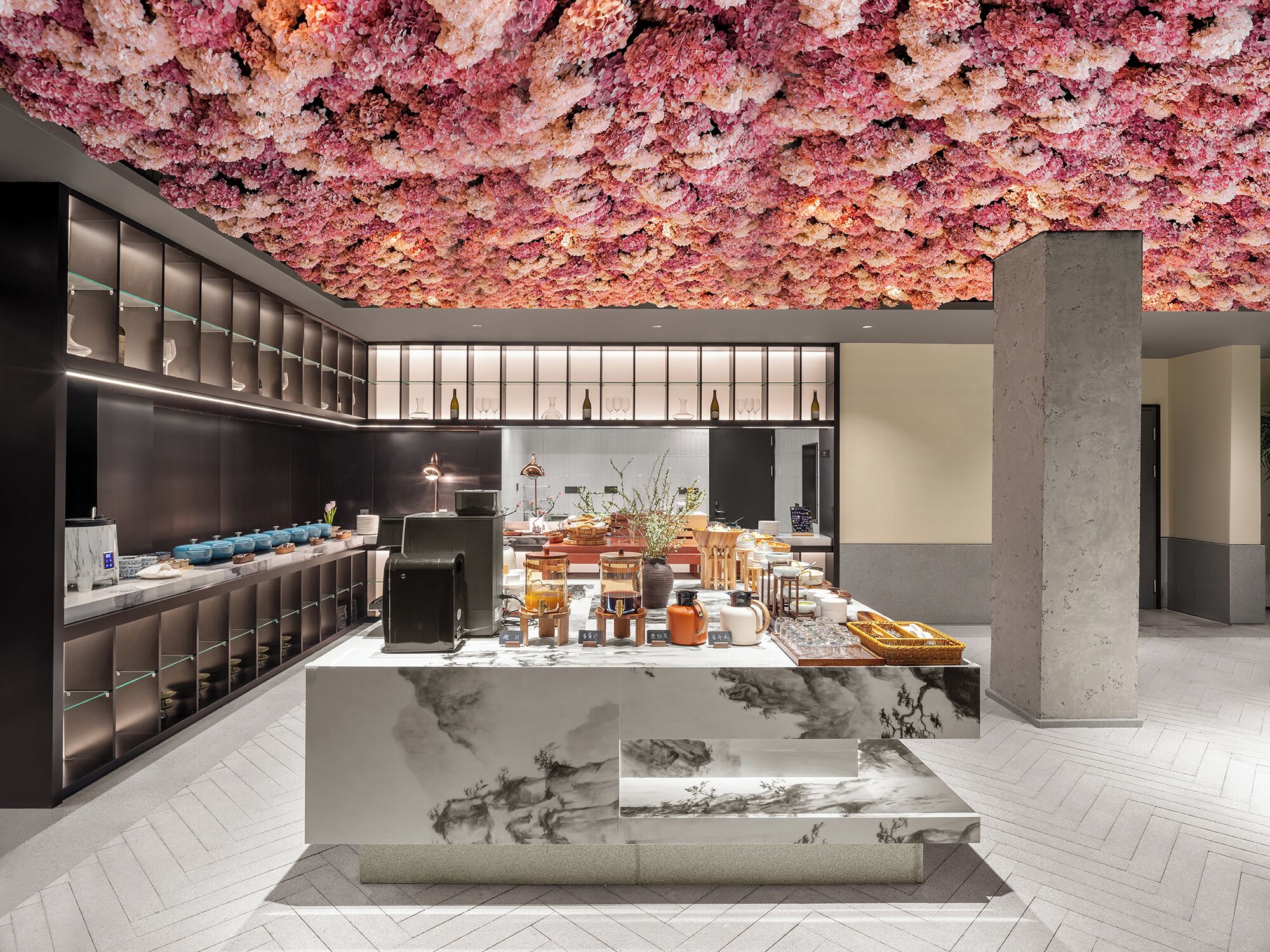 A modern interior with a central island, dark cabinetry, and a ceiling adorned with pink flowers.