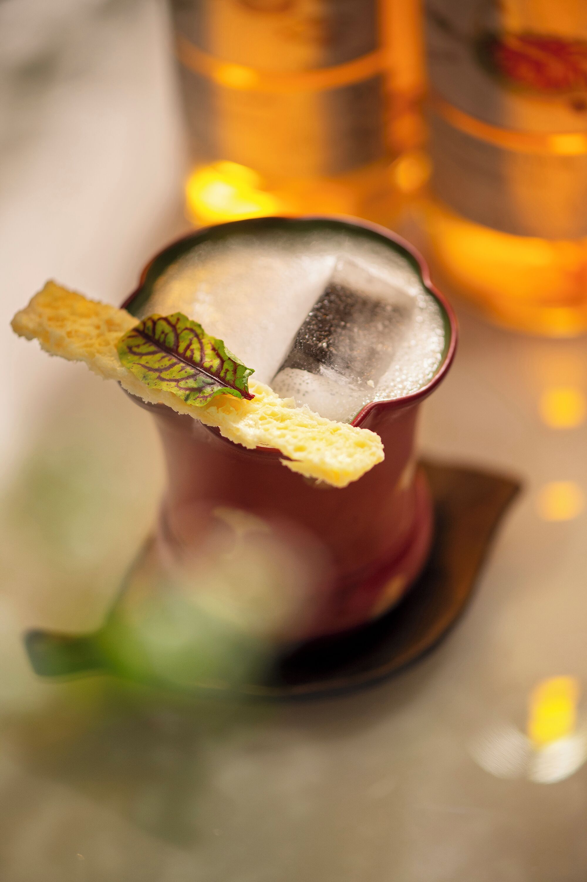 Et nærbillede af en cocktail med pynt, is og et glas.