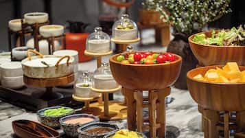 A buffet with various food items and condiments.
