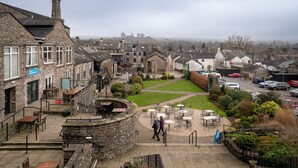Un bâtiment en pierre doté d’une terrasse et offrant une vue sur la ville.