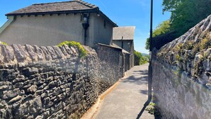 A narrow street flanked by stone walls and buildings with pitched roofs. - Bowling Fell Cottage -  Kendal Townhouse with Views (Kendal)
