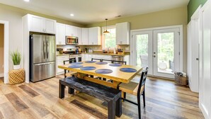 A modern kitchen with a large island, stainless steel appliances, and a dining area with a bench. - 1 Mi to Lake Hartwell: Updated Retreat w/ Patio! (Anderson)