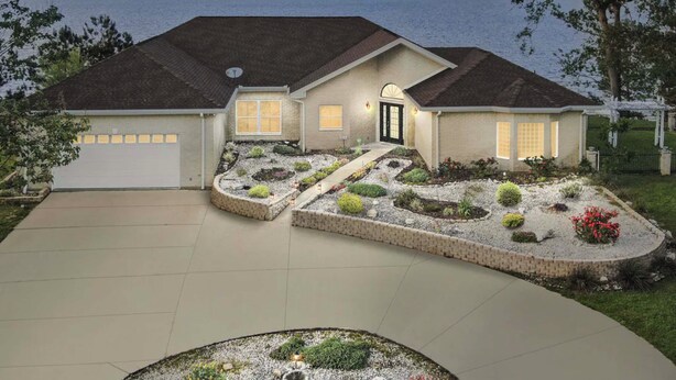 A two-story house with a garage, landscaped garden, and a view of the water. - Boat Dock & Hot Tub: Waterfront Home in Milam! (Milam)