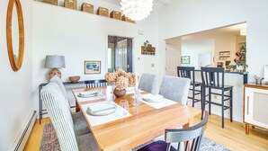 A dining area with a wooden table, chairs, and a hanging light fixture. - Family Getaway w/ Deck: 3 Mi to Lake Champlain (Colchester)