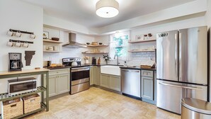A modern kitchen with stainless steel appliances, wooden cabinets, and a hanging pot rack. - Family Getaway w/ Deck: 3 Mi to Lake Champlain (Colchester)