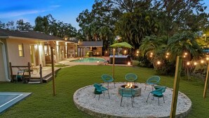 A backyard with a fire pit, chairs, and a pool. - Sleeps 20~Heated Pool~Pickleball~Hot Tub~Fire Pit (Largo)
