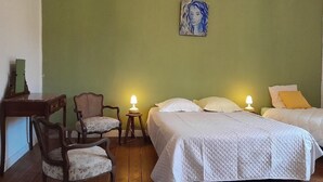 Een kamer met twee bedden, een bureau en twee stoelen.
