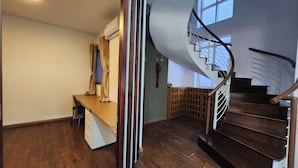 A staircase with a wooden handrail and a curved design, leading to an upper floor.