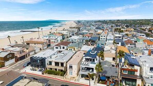 A coastal residential area with houses, a beach, and a clear sky. - 3BR + Loft Ocean View | Rooftop, Hot Tub, Parking (Newport Beach)