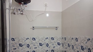 A bathroom with a toilet, shower, and a water heater. - Hotel RRR (Jakholi)