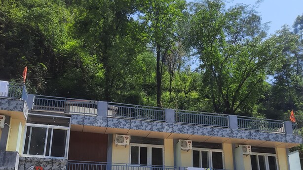 A hotel with a two-story structure, balconies, and air conditioning units. - Hotel RRR (Jakholi)