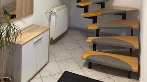 A modern staircase with wooden steps and grey cushioned seating. - Vacation apartment Allgäuherz Relax on lovingly furnished 55 sqm (Unknown)