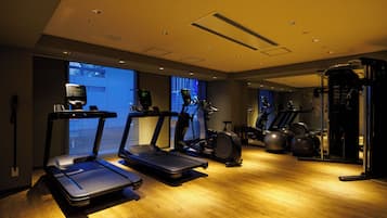 A gym with treadmills, elliptical machines, and exercise balls.