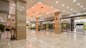 A spacious lobby with a tiled floor, large pillars, and modern lighting fixtures. - Bugok Royal Hotel (Changnyeong)