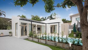 A modern house with a swimming pool, large windows, and a well-maintained garden.