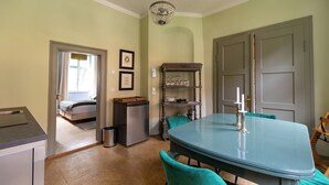 A dining area with a teal table and chairs, a chandelier, and a wooden buffet stand. - Spend the night in a monument in the middle of Halberstadt's old town (Halberstadt)