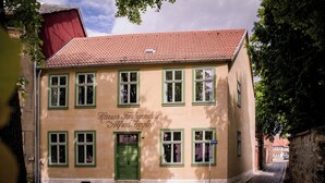 A building with a red-tiled roof and green-framed windows, labeled "Hauptsiedlung Alfredstiegel". - Spend the night in a monument in the middle of Halberstadt's old town (Halberstadt)
