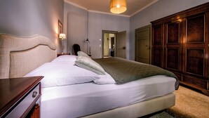A neatly made bed with a headboard, a bedside lamp, and a wooden wardrobe. - Spend the night in a monument in the middle of Halberstadt's old town (Halberstadt)