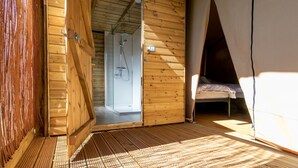 Une cabane en bois avec une salle de douche et un lit.