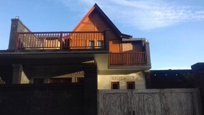 A two-story building with a wooden balcony on the upper floor.