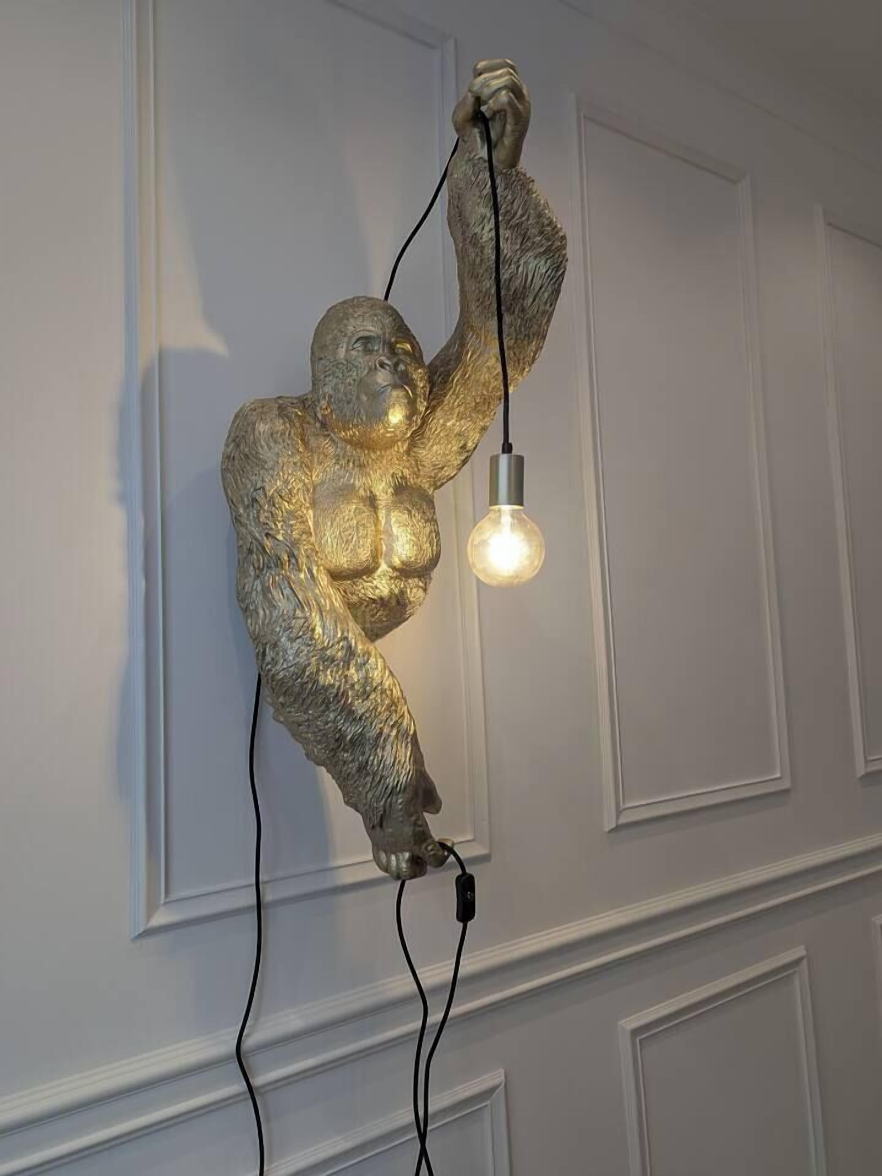 Eine Wandskulptur eines Gorillas, der eine Glühbirne in der Hand hält.
