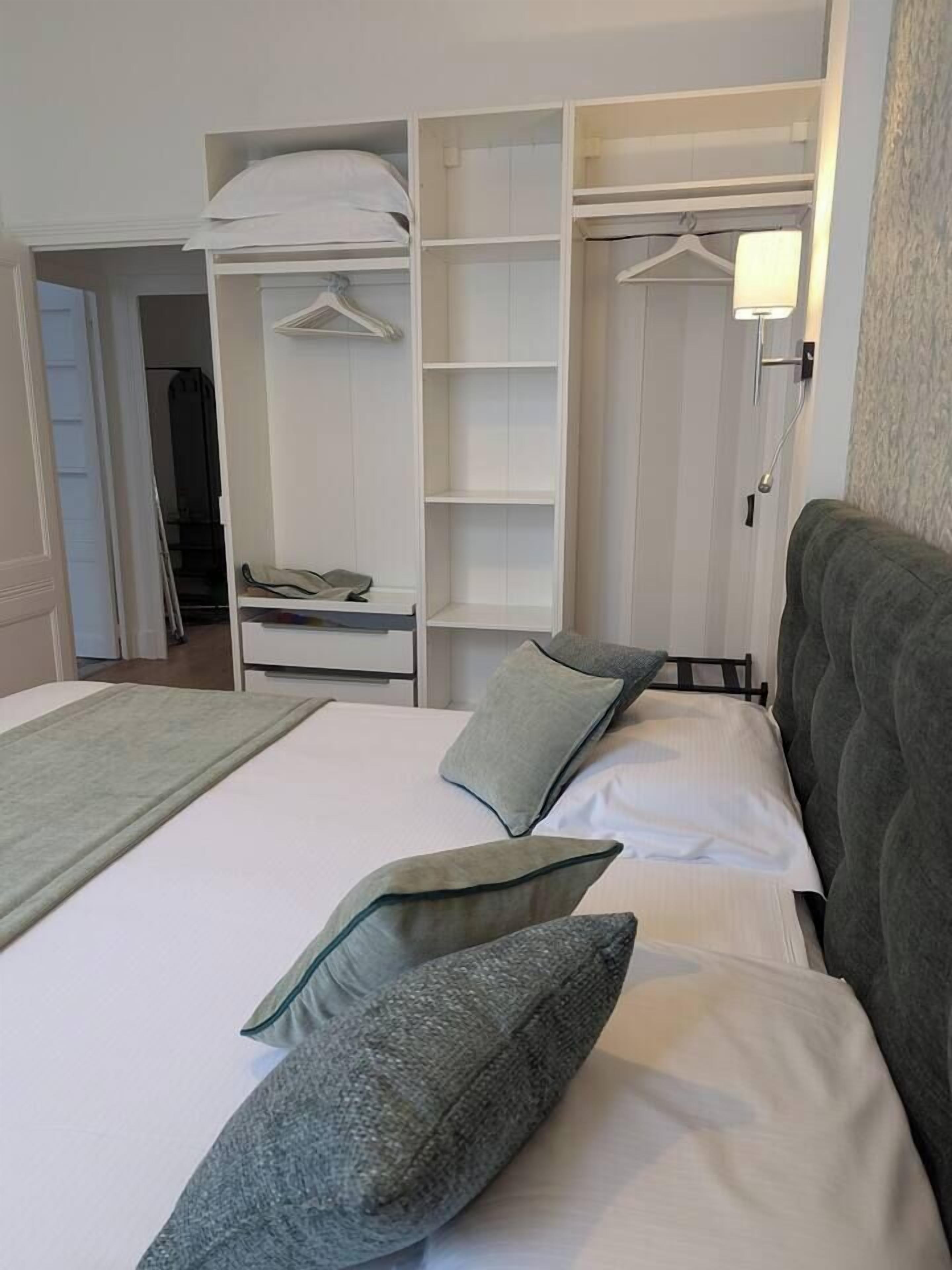 Une chambre d’hôtel avec un lit, une armoire et une table de chevet.