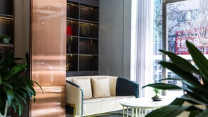 Un intérieur moderne avec un canapé, une petite table ronde et une bibliothèque.