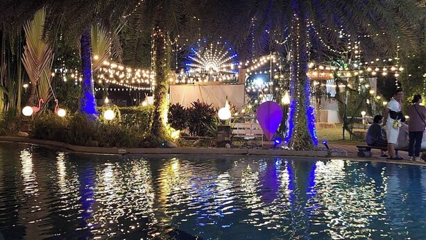 A poolside area with string lights, palm trees, and a water feature. - Supalai Pasak Resort Hotel and Spa (Tha Khlo)
