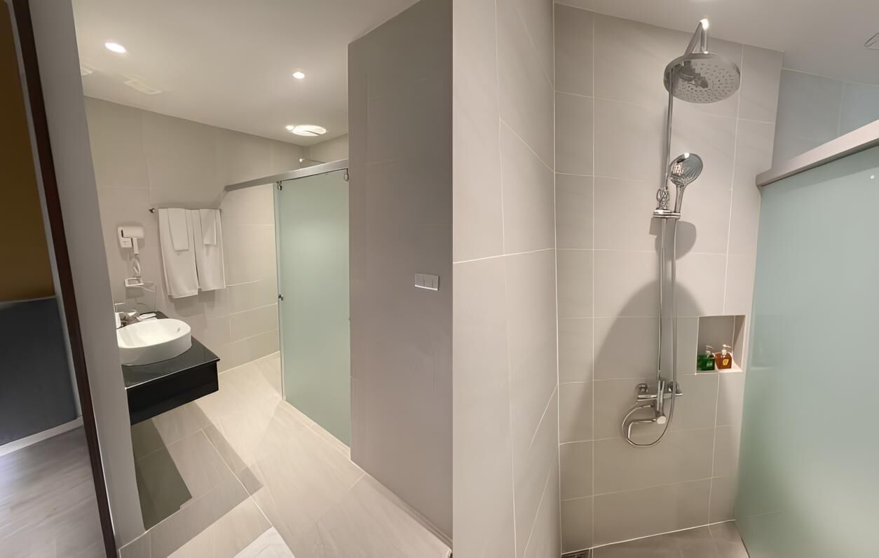 A modern bathroom with a shower, sink, and glass-enclosed walk-in shower.