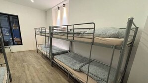 Ein Schlafraum mit Etagenbetten, einem Fenster und einem Schreibtisch.