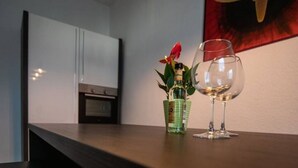 Una encimera de cocina con una botella de licor y una copa de vino.