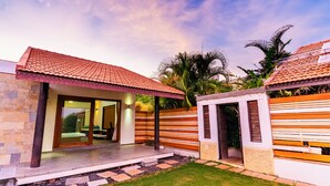 A modern house with a tiled roof, a glass door entrance, and a well-maintained lawn. - Cherry Villa,Nashik by Ebony Stays | Cosy 4BHK Villa in Nashik with Scenic Views (Nashik)