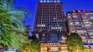 A hotel with a modern facade, multiple floors, and a prominent sign in the center.