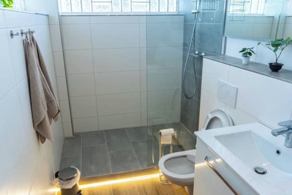 Un baño moderno con ducha, inodoro y lavamanos.