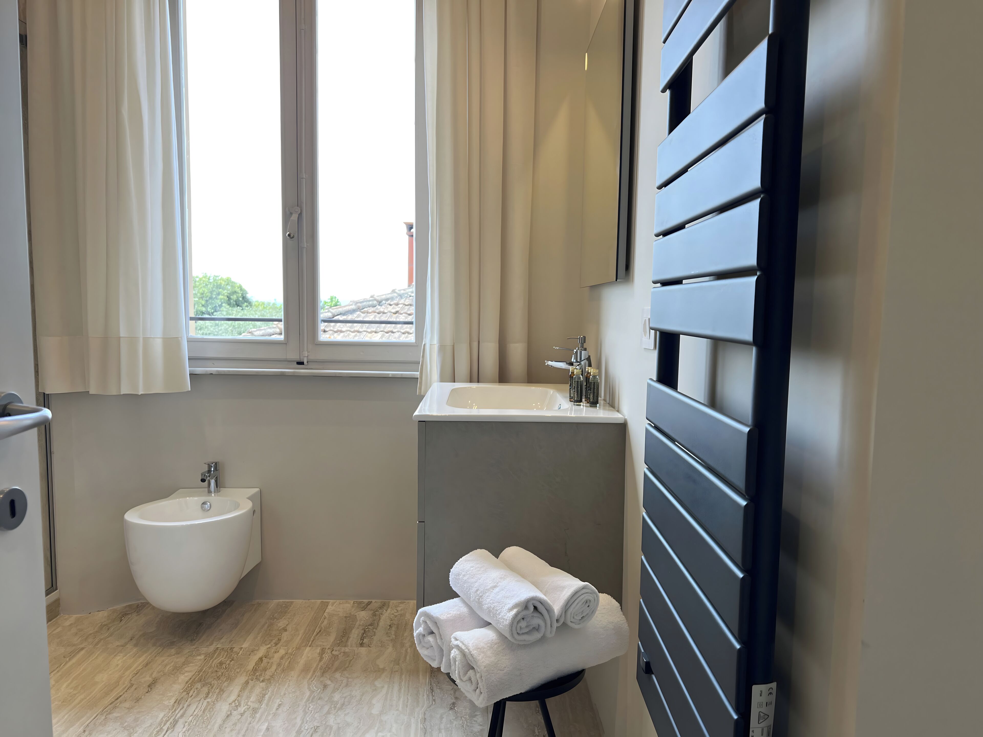 Ein modernes Badezimmer mit einer Bidet, einem Waschbecken und einem Handtuchhalter.