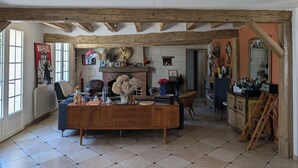 A rustic interior with exposed wooden beams, a fireplace, and a variety of decorative items.