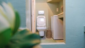 Ein kleines, kompaktes Badezimmer mit Toilette, Bidet und einem weißen Waschbecken.