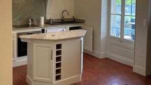 A kitchen with a central island, pendant lights, a window, and a door leading outside.